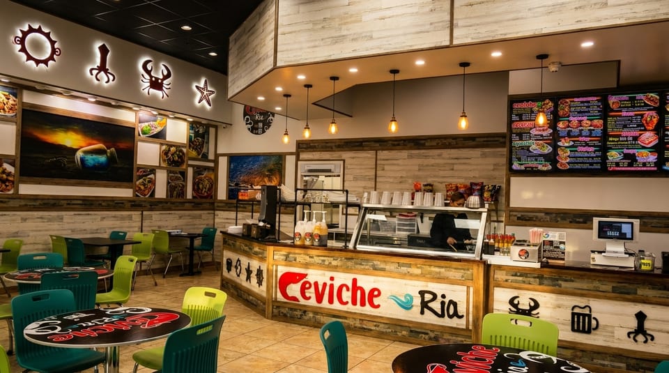 Interior of Ceviche Ria restaurant with tables, chairs, a counter, menu boards, and marine-themed decor.